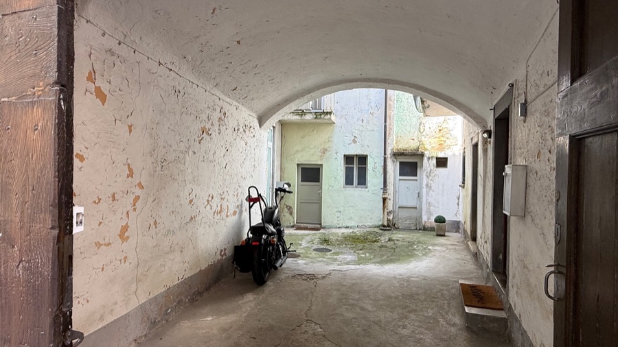 Corte coperta con passaggio ad arco e due porte esterne dei locali di servizio