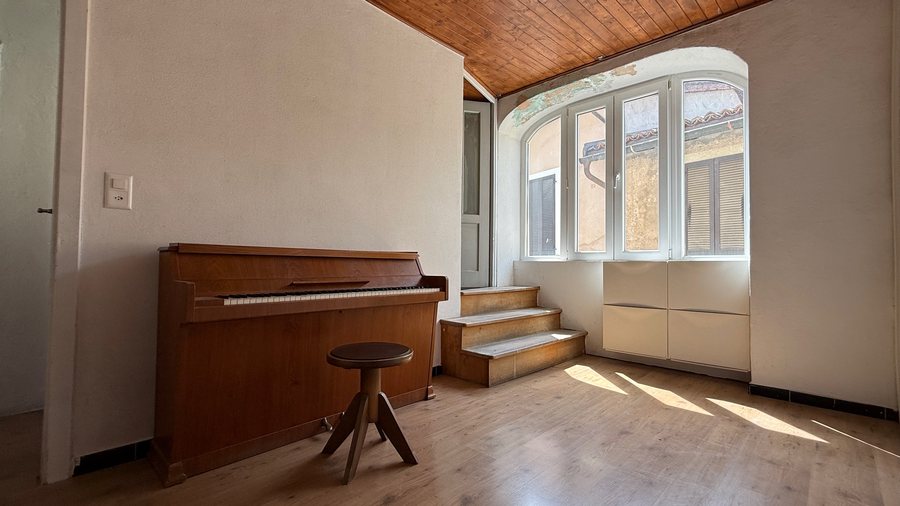 Atrio luminoso con pianoforte, stufa a pellet, soffitto in legno e ampia finestra ad arco