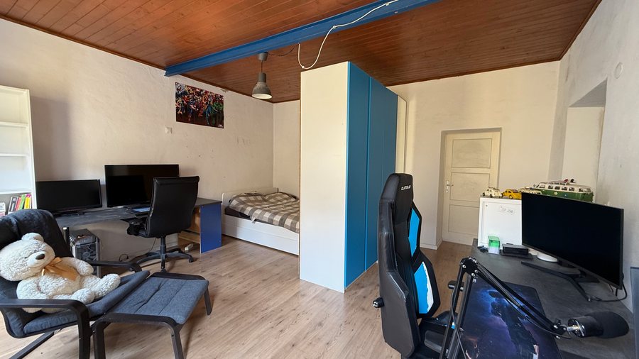 Ampia camera organizzata anche come studio con letto, scrivanie e soffitto in legno