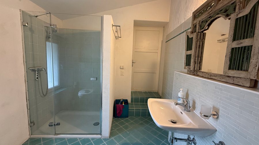 Bagno azzurro del secondo piano con ampia doccia in vetro e lavabo