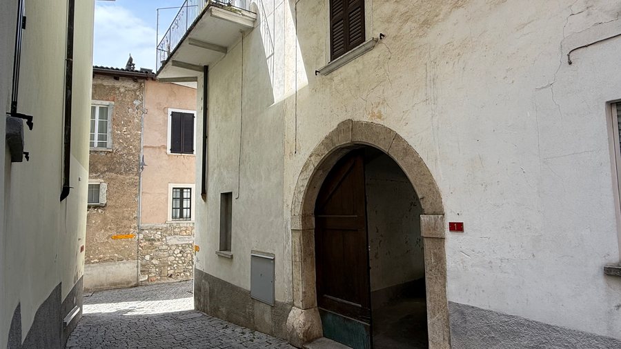 Portone ad arco della casa affacciato su una viuzza acciottolata di Besazio